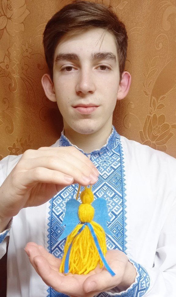 Оскар Ситніков демонструє янголятко оберіг для воїнів ЗСУ